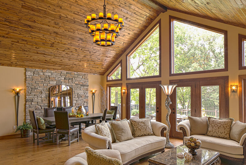 {Trapezoid shaped wood clad architectural windows inside a rustic living room; example of shaped windows in ProVia's window gallery}