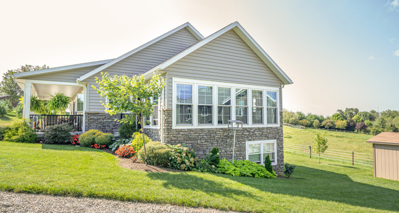 {A row of Aspect double hung windows on the outside of a home with a view of Midwestern countryside in the distance}