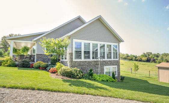 {A row of Aspect double hung windows on the outside of a home with a view of Midwestern countryside in the distance}