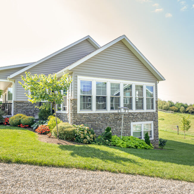 {A row of Aspect double hung windows on the outside of a home with a view of Midwestern countryside in the distance}