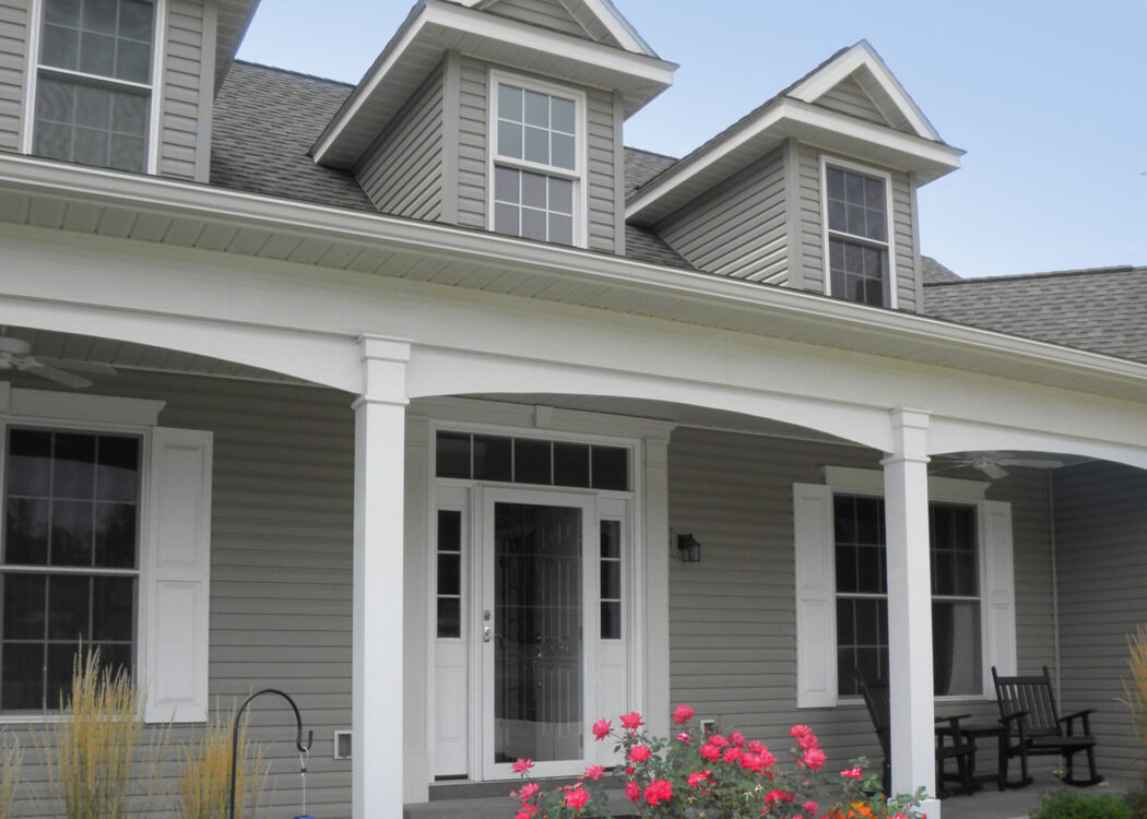 {Ultra vinyl lap siding in the color Gray, example of a Cape Cod style home with Cape Cod style front door and windows.}