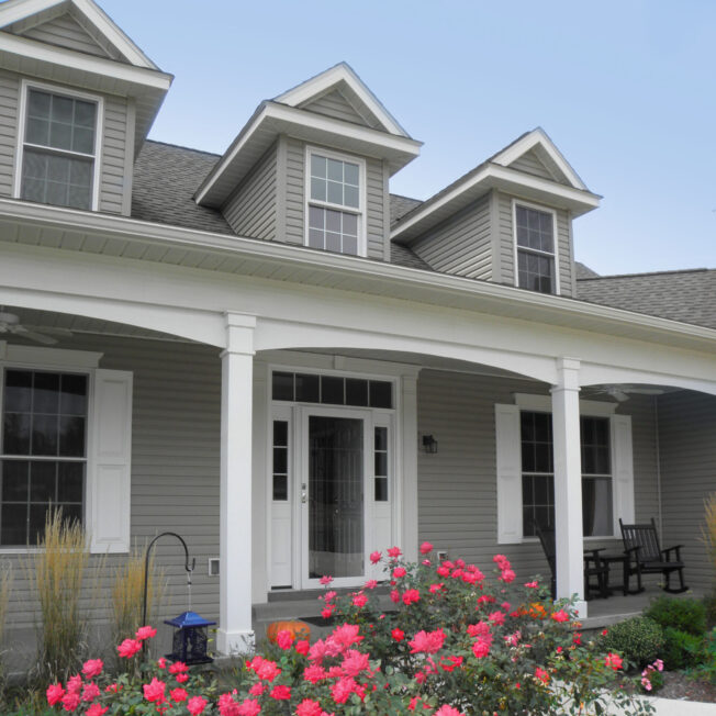 {Ultra vinyl lap siding in the color Gray, example of a Cape Cod style home with Cape Cod style front door and windows.}