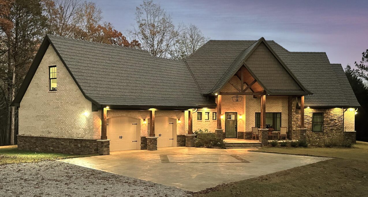 {Photo of a home at dusk with ProVia's Larkstone Slate metal roofing and Shawnee Dry Stack stone}