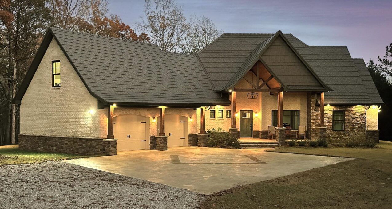 Photo of a home at dusk with ProVia's Larkstone Slate metal roofing and Shawnee Dry Stack stone