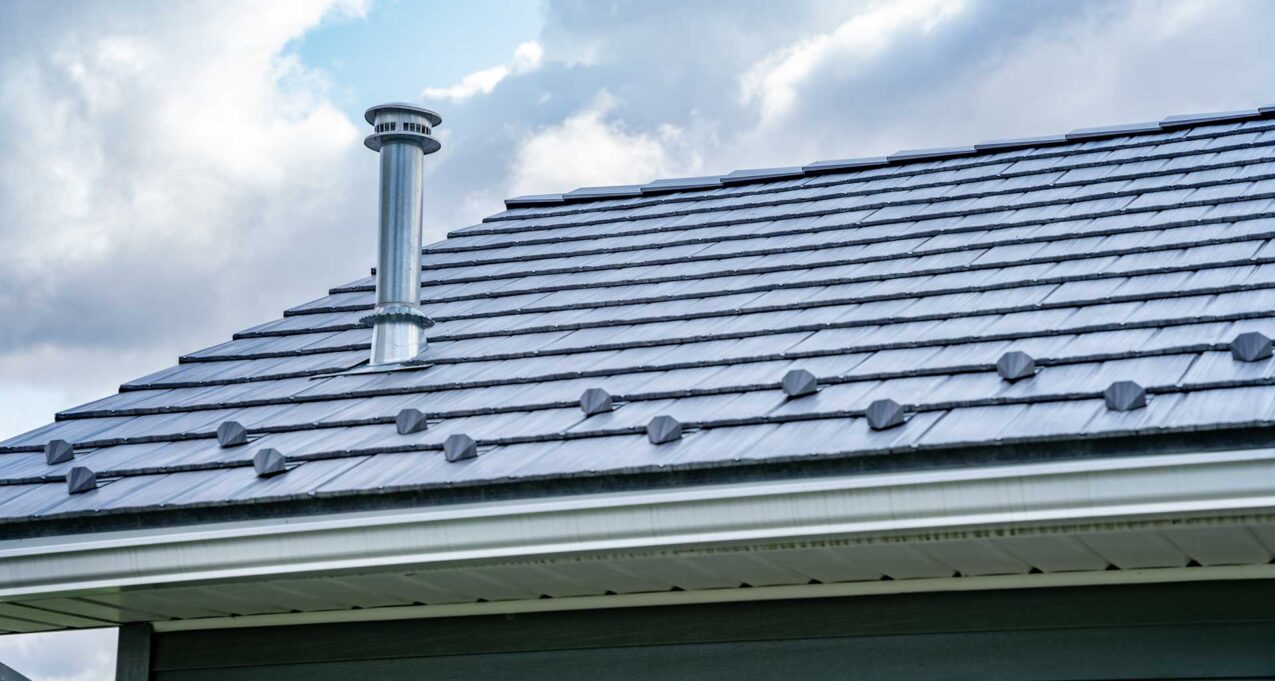 {Closeup of a home with ProVia's gray Pepperwood Shake metal shingle roof that resembles the look of shake shingles}