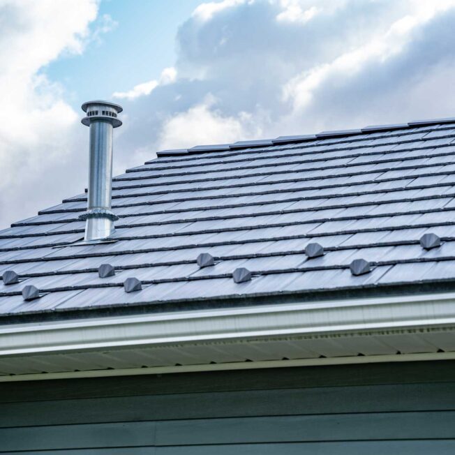 {Closeup of a home with ProVia's gray Pepperwood Shake metal shingle roof that resembles the look of shake shingles}