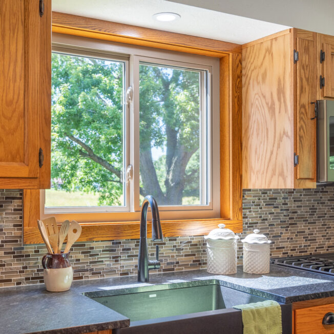 {Inside view of Aspect slider windows in Sandstone beige above a kitchen sink}
