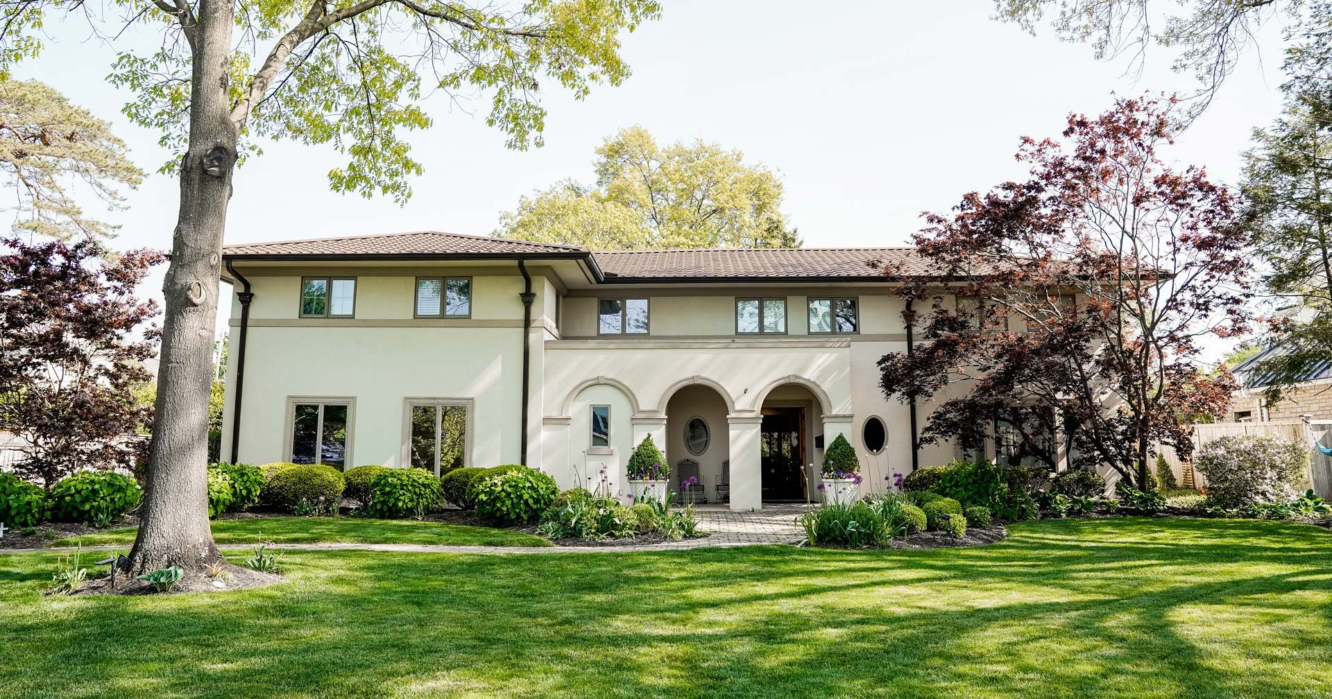 {Spanish-style home with a nice front yard and ProVia barrel tile metal roofing}