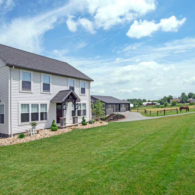 {HeartTech vinyl siding in White on a two-story colonial-style home in the country}