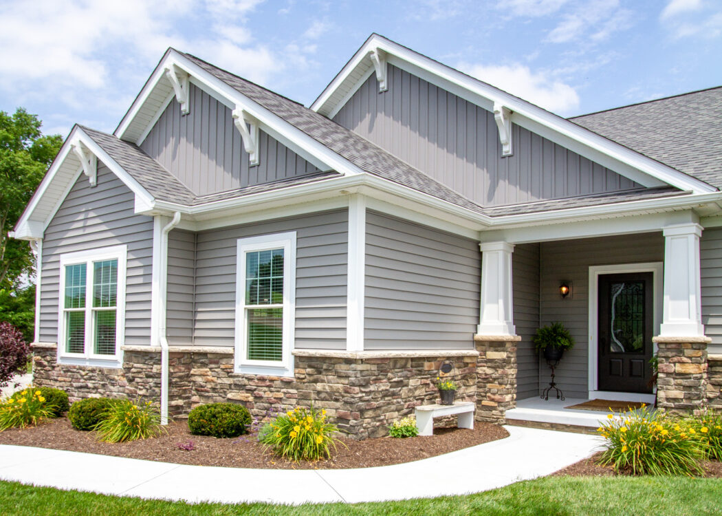 {House with ProVia vinyl siding HeartTech double 5" in Granite with a manufactured stone knee wall}