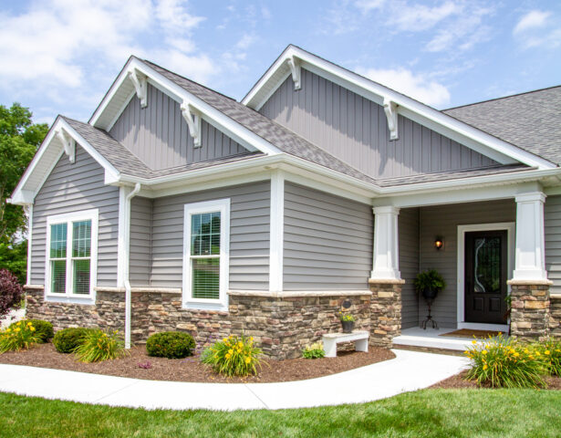 {House with ProVia vinyl siding HeartTech double 5" in Granite with a manufactured stone knee wall}
