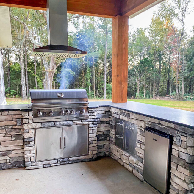 {Outdoor kitchen featuring ProVia's Ledgestone veneer in Mystic, a gray ledgestone}