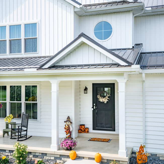 White home exterior with round window; example of shaped windows in ProVia's window gallery