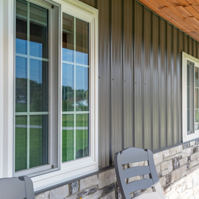 {Outside view of white sliding windows with cottage-style grids}