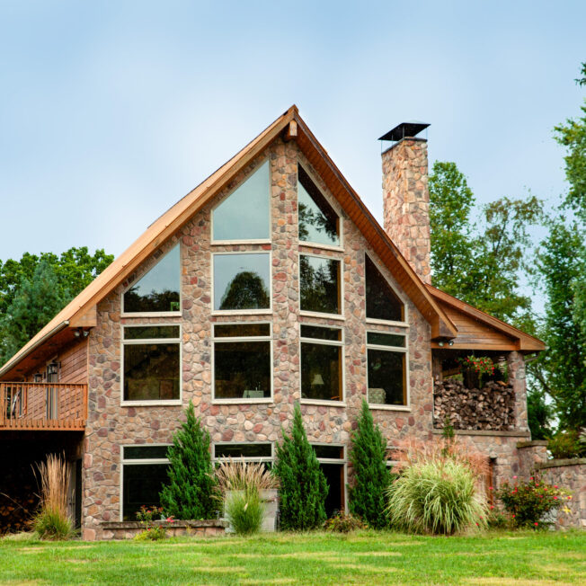 {Brown and tan field stone veneer manufactured stone, Shenandoah, on an A-frame house}