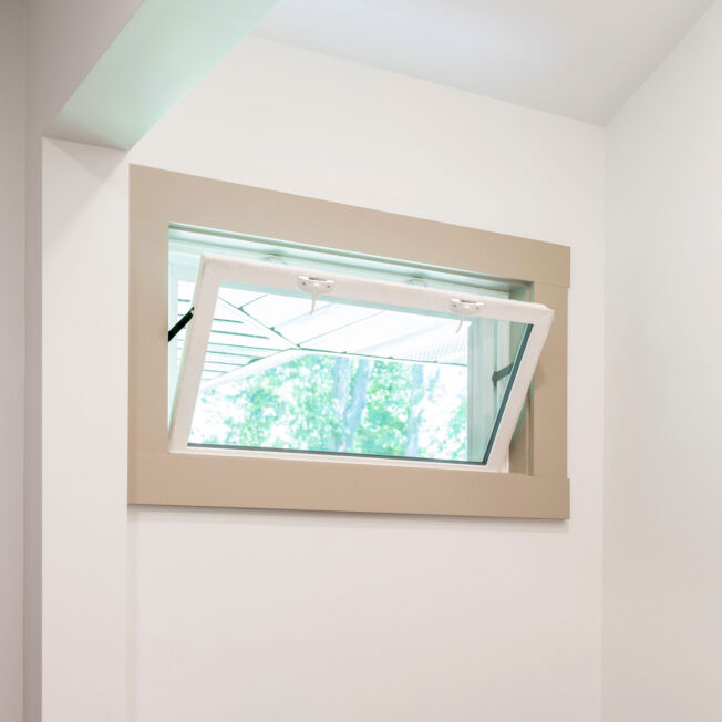 An opened Sandstone colored hopper window in a laundry room