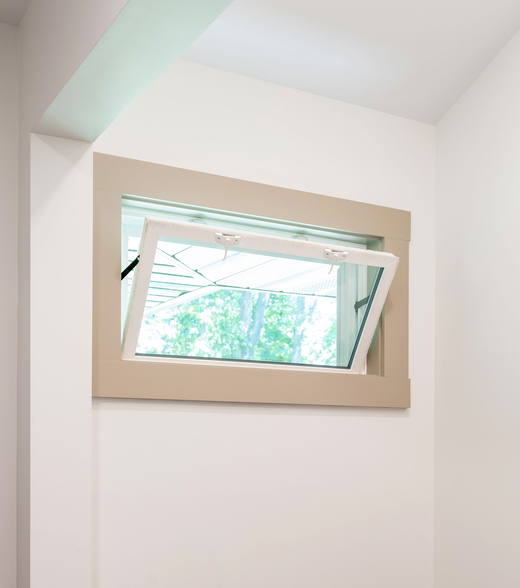 An opened Sandstone colored hopper window in a laundry room