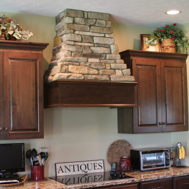 {Osage Ledgestone accents in a kitchen on a range vent hood. Manufactured stone is among one of the top value added home improvements.}