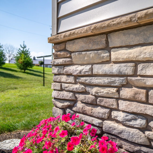 {Closeup of Ledgestone veneer in the color Brighton on the foundation of a home}