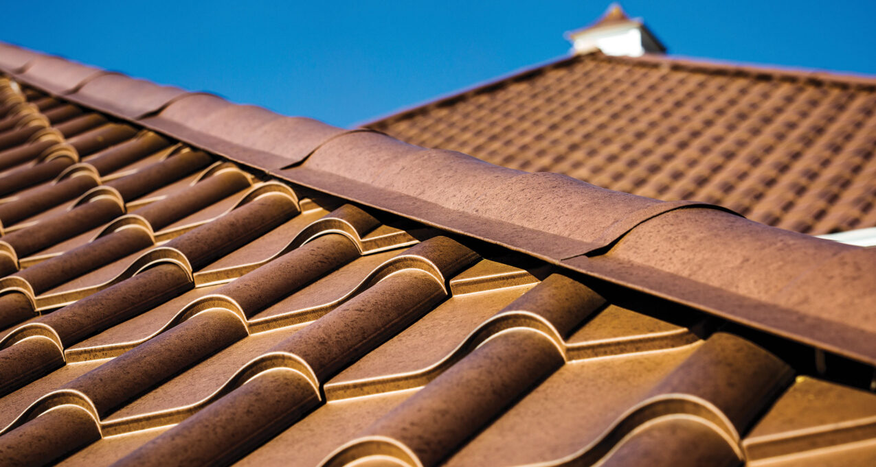 {Closeup image of ProVia Metal Barrel Tile Roofing in Terracotta installed on a home}