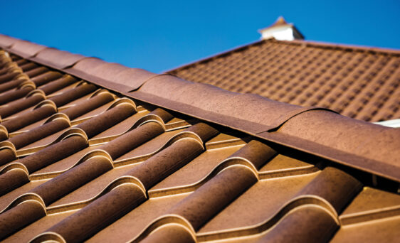 {Closeup image of ProVia Metal Barrel Tile Roofing in Terracotta installed on a home}