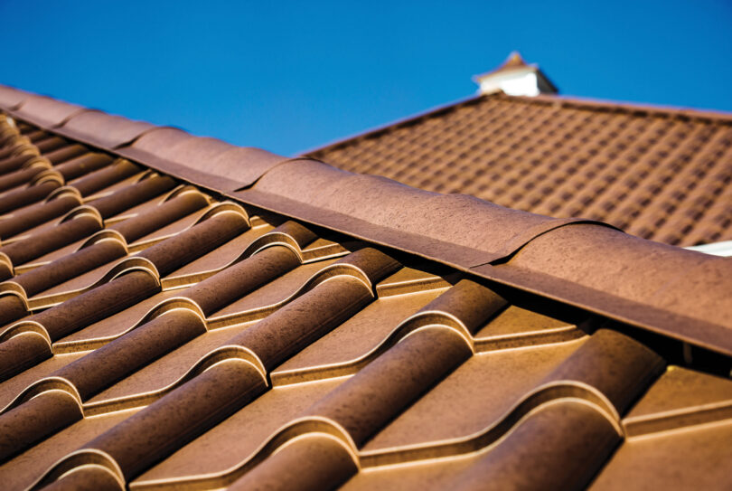{Closeup image of ProVia Metal Barrel Tile Roofing in Terracotta installed on a home}