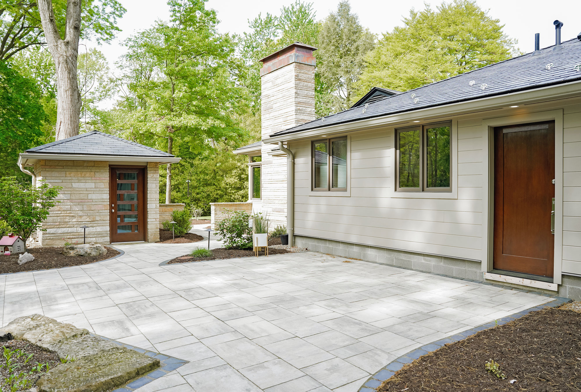 The back of a house showing a Signet® 001C entry door in Truffle stain and a nicely landscaped patio