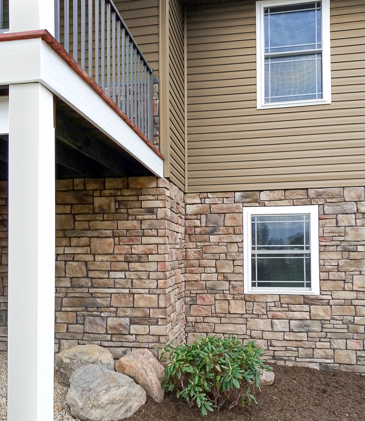 ProVia Terra Cut manufactured stone on the lower level of a home in the color Russet, example of how exterior stone for houses can be used