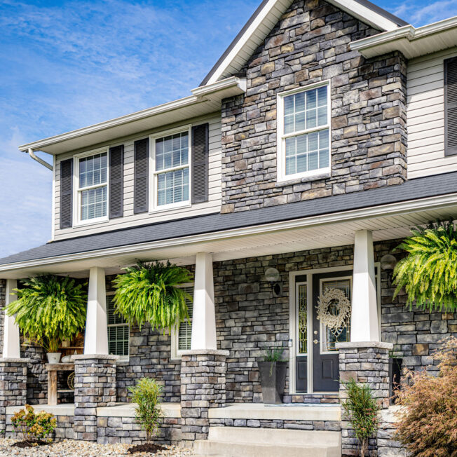 {Picture of a two-story home with Terra Cut Stone Veneer, example of a home exterior stone application}