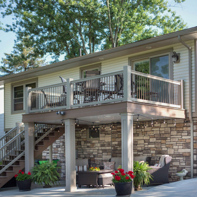 {Image showing the back of a home with a walkout basement displaying ProVia Terra Cut™ manufactured stone in the color Summit}