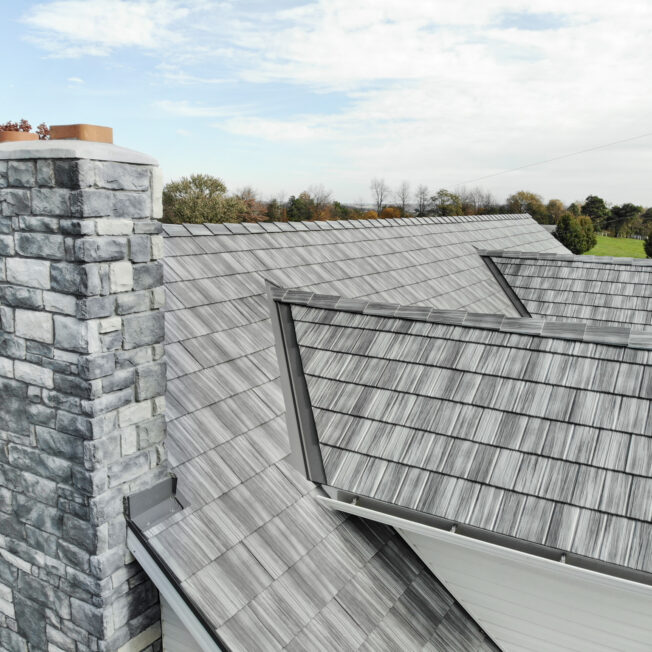 {Home with ProVia's gray Pepperwood Shake metal shingle roof showing that metal roofs can resemble the look of shake shingles}