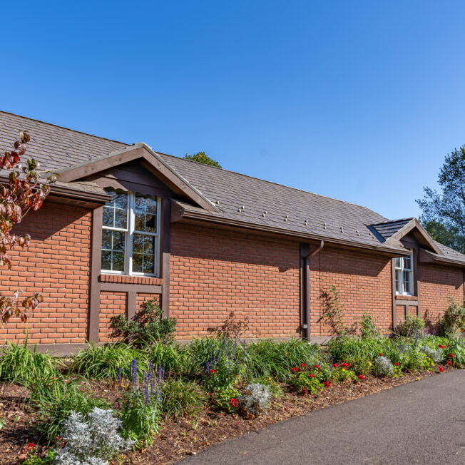 {Photo of a brick home with ProVia's Lodgestone slate metal roofing, a brown color}