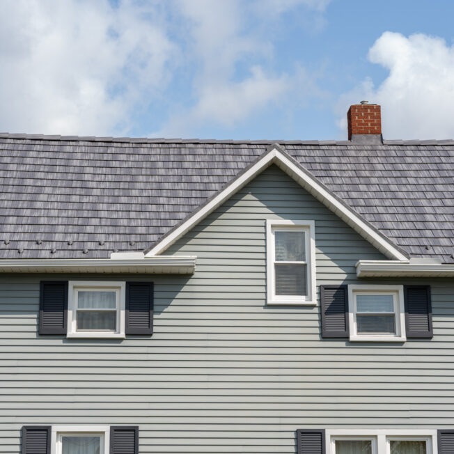 {Home with ProVia's gray Pepperwood Shake metal shingle roof showing that metal roofing can resemble the look of shake shingles}