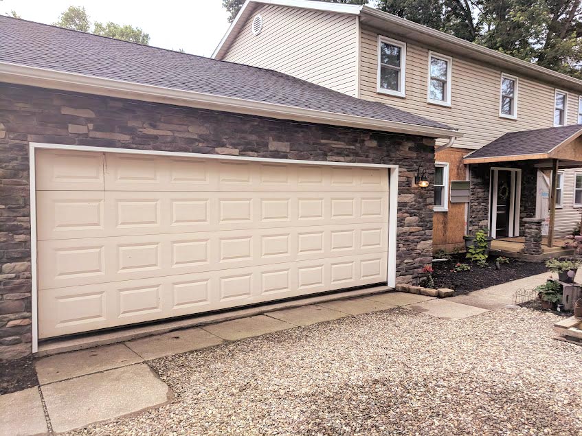Two-story home with older, cream-colored siding before the home received new ProVia vinyl siding