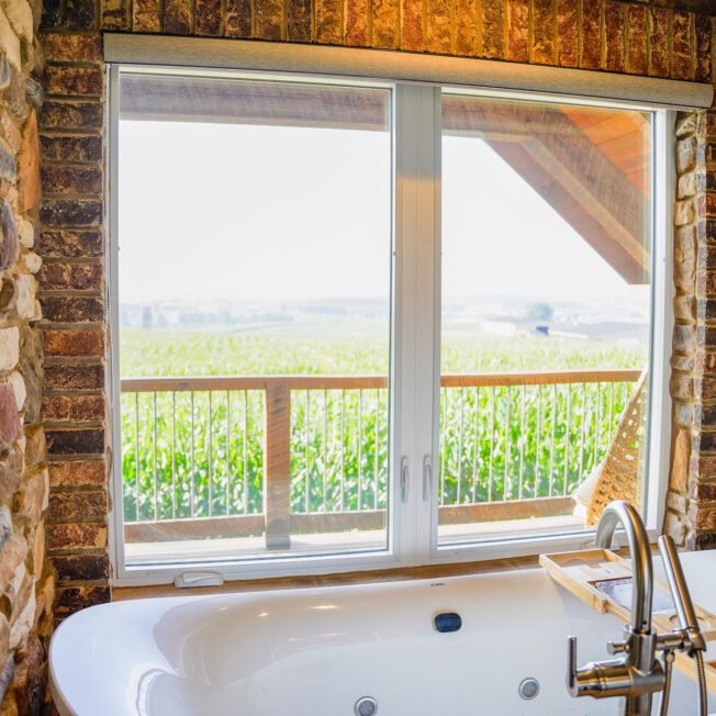 {Interior view of Endure™ Casement Windows in White in a bathroom with a view of the countryside}