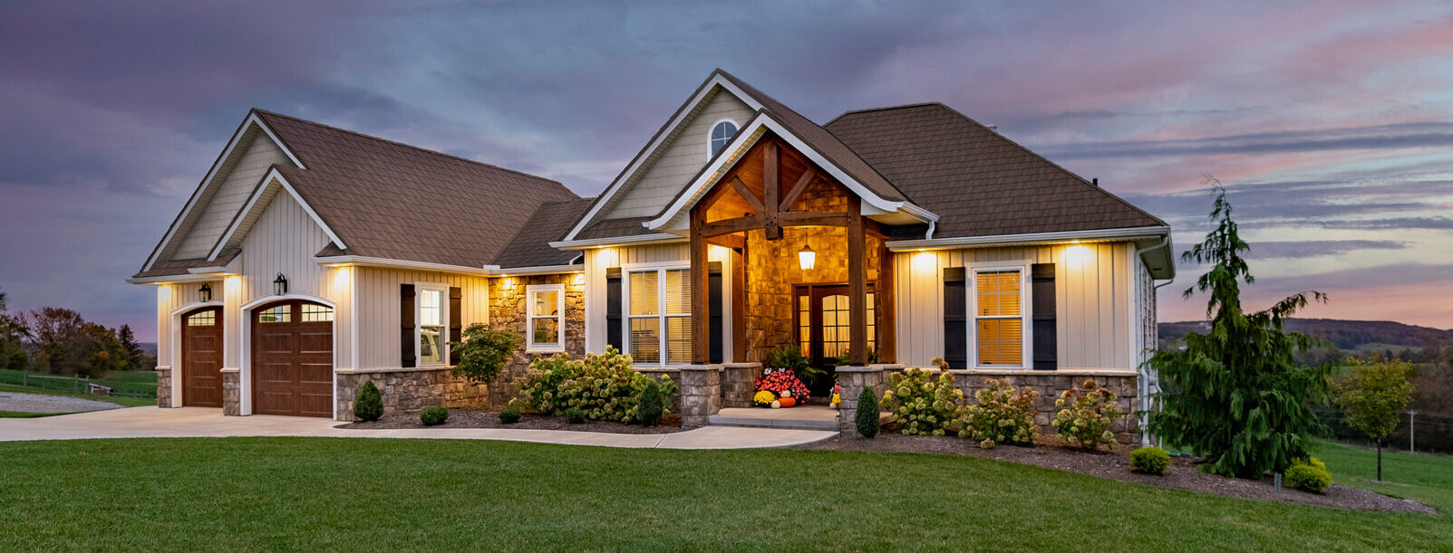 Exterior view of a home with ProVia doors, windows, vinyl siding, manufactured stone, and metal roofing, demonstrating ProVia's home exterior solutions