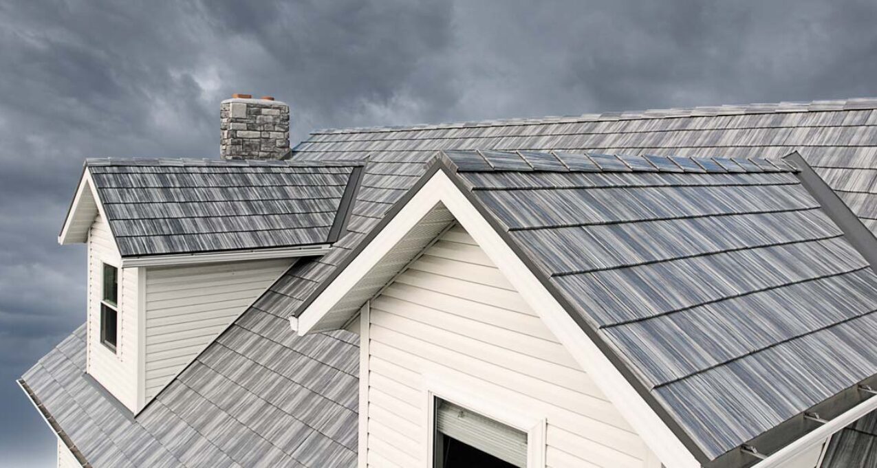 {Closeup image of a stormy sky and ProVia Pepperwood Shake metal house roofing system}