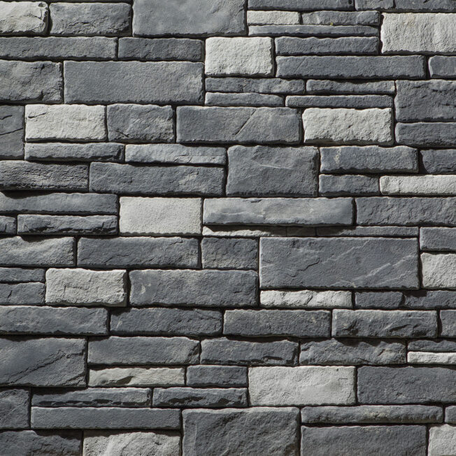 {Closeup of manufactured dry stack stone veneer in a color called Erie, which is a mix of light and dark gray stone}
