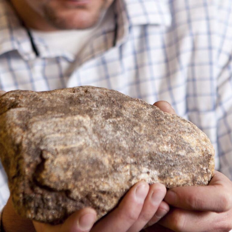 Man holding a stone representing hand selection of stone veneer molding during stone veneer manufacturing process