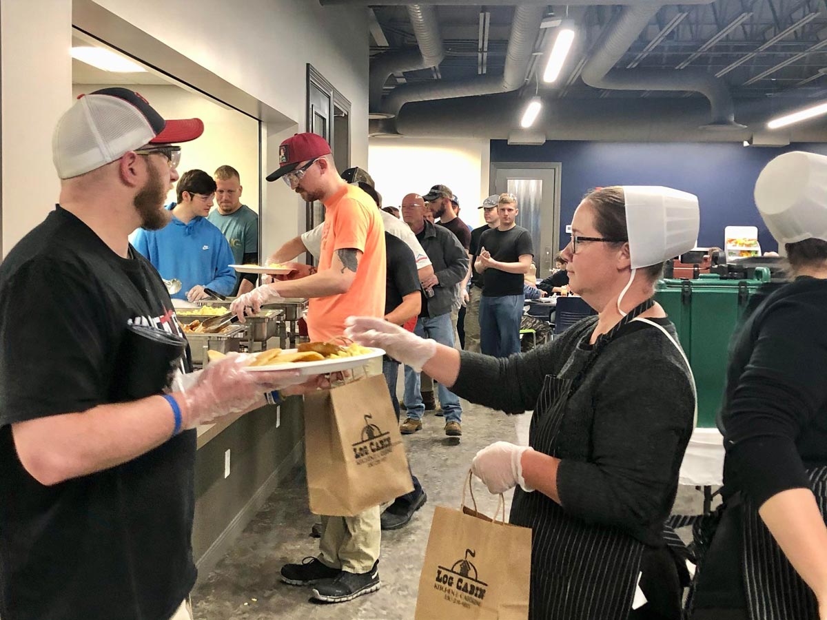 ProVia employees line up for breakfast at a monthly corporate event.