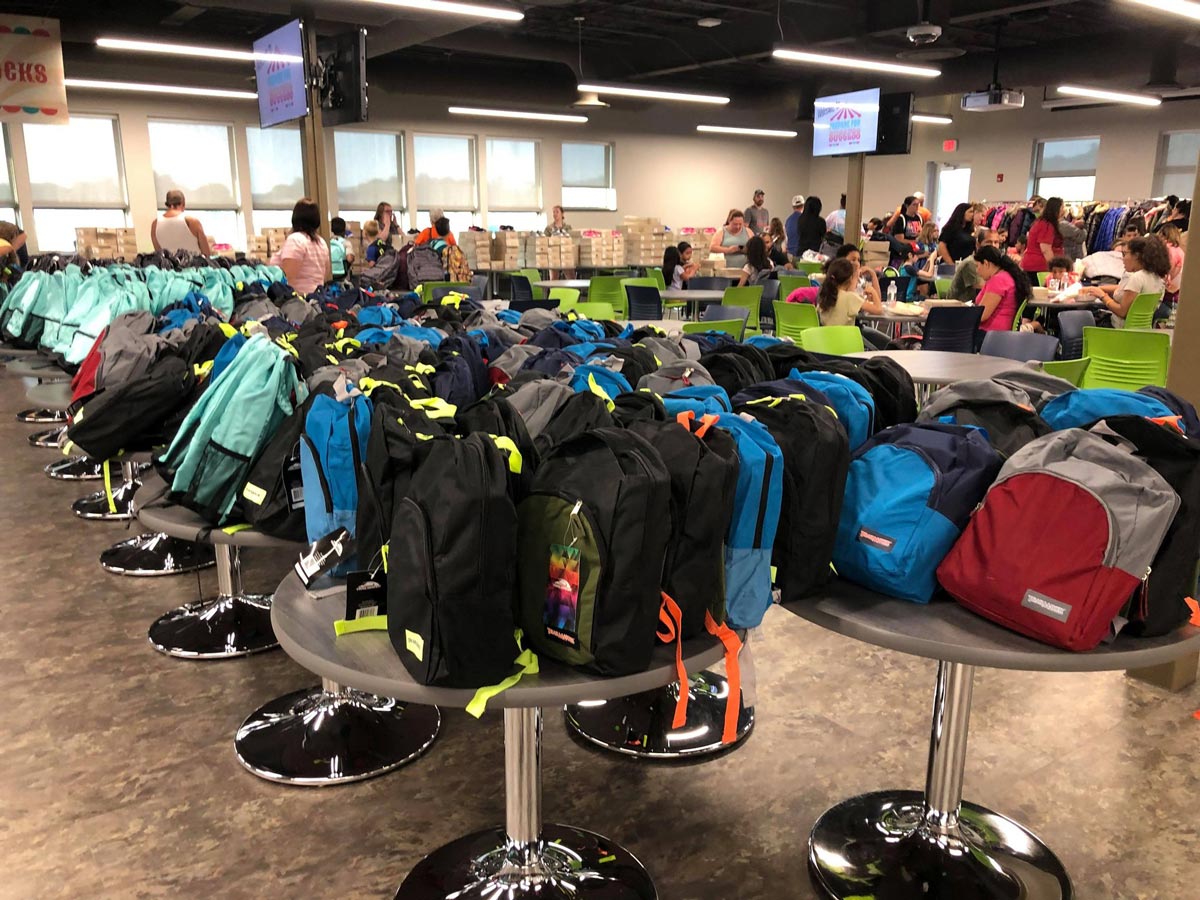 Free backpacks stuffed with school supplies line the lunchroom at ProVia at annual Prepare for Success event