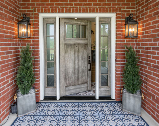 {Signet fiberglass fir door and sidelites in Natural Leather gray glaze on the porch of a red brick home}