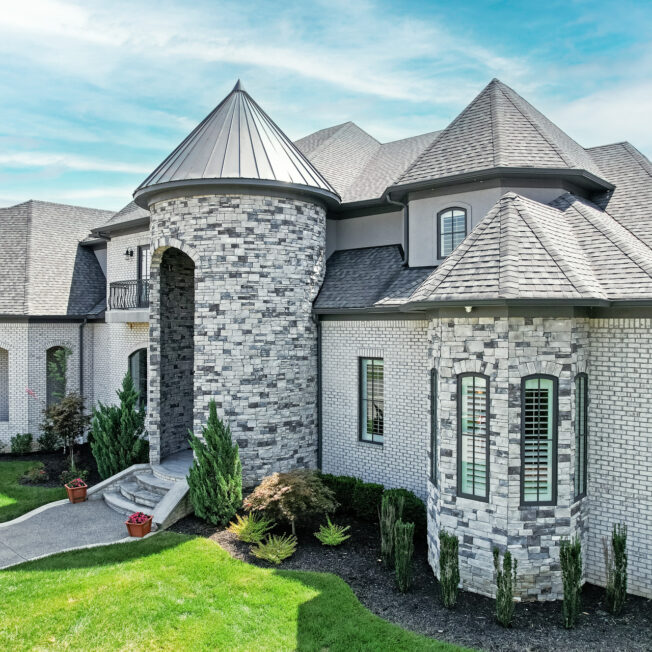 {Terra Cut™ Manufactured Stone in the color Frost on the exterior of a nice home with turrets}
