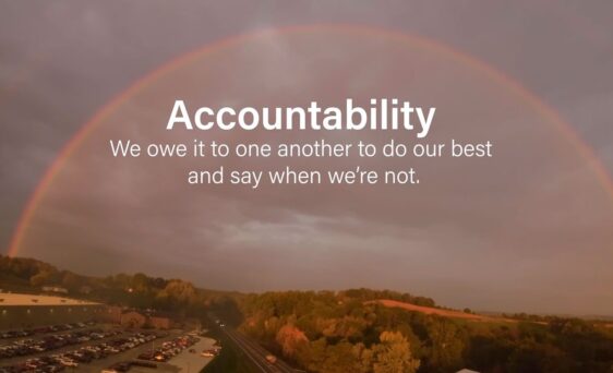 {Image of a rainbow over some trees, a highway, and a parking lot with the words: "Accountability—We owe it to one another to do our best and say when we're not."}