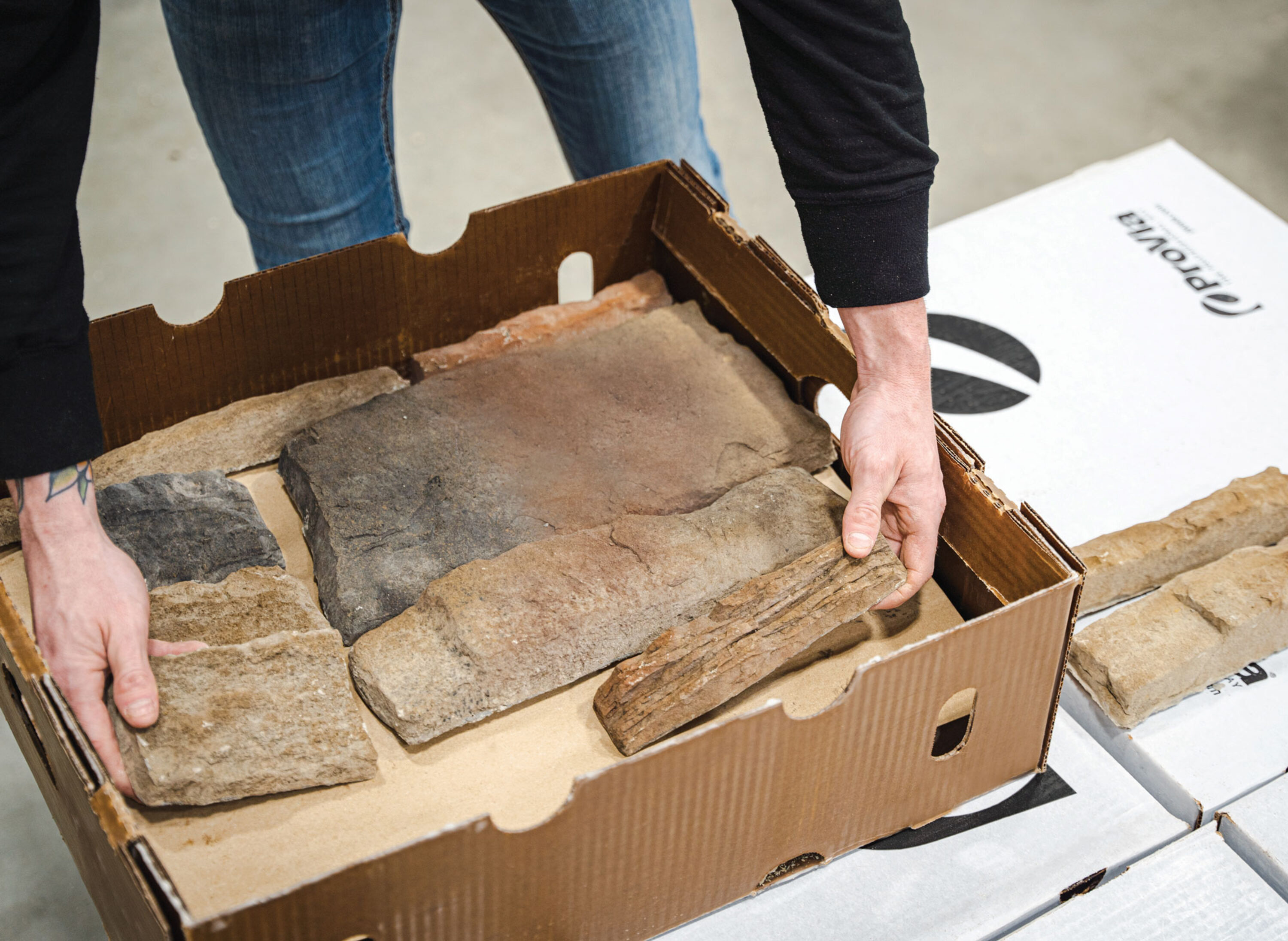 An employee packaging ProVia manufactured stone carefully into a box