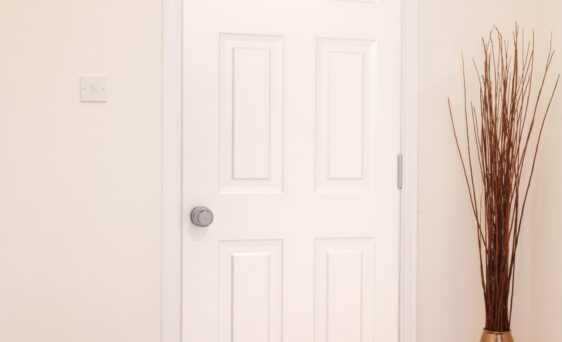 {Inside view of a white Legacy™ 006 steel entry door in an apartment}
