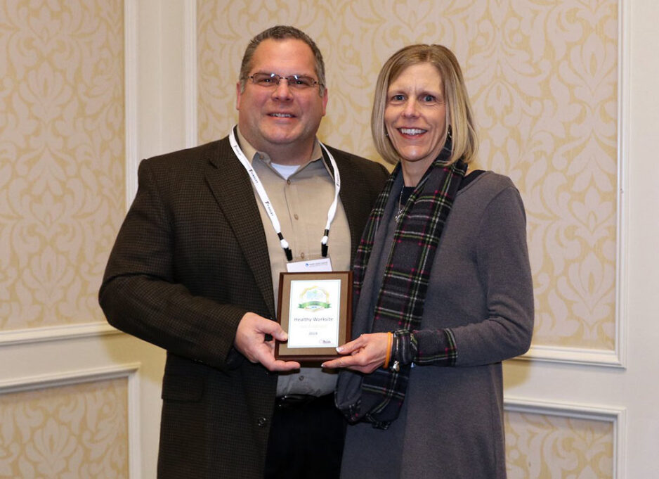 {Tricia Hicks (right), Wellness Specialist, accepts 2019 Gold award on behalf of ProVia}