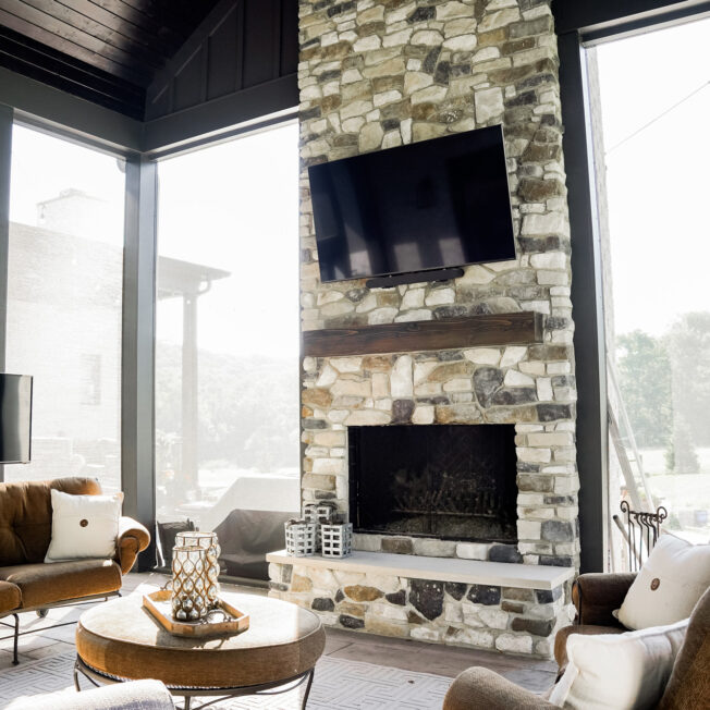 {Ridge Cut™ manufactured stone in the color Denali on a fireplace in a sunroom}