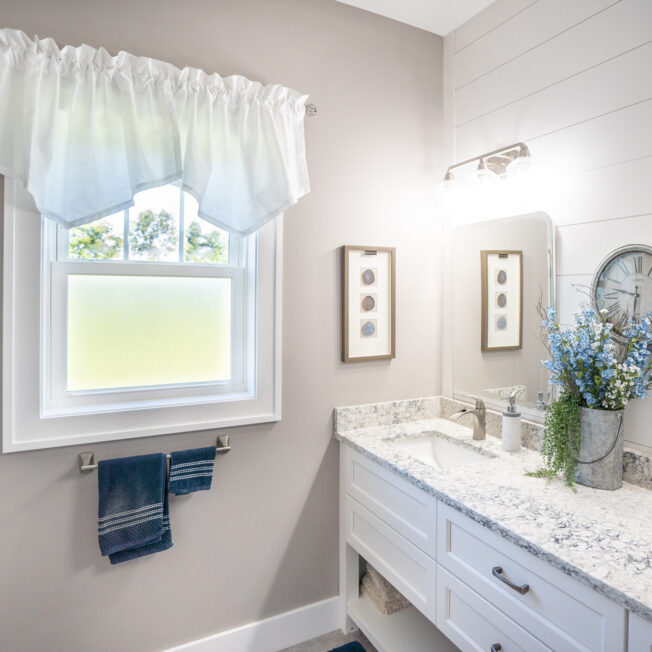 {Inside view of a white bathroom with a ProVia Endure™ Double Hung Windows in White with Obscure Pebble Privacy Glass}