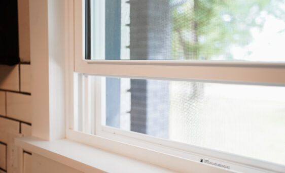 {Closeup view of an open ProVia vinyl window showing the built in window screen}